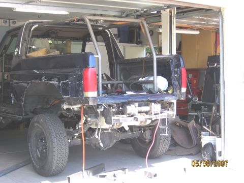 1994 Ford Bronco - Modified 1992 Ford Bronco in garage, showing rear end with winch and roll cage.