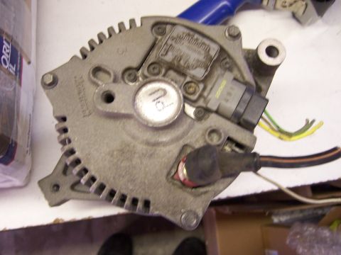 1991 Ford Bronco - Close-up view of an alternator, showing its metallic casing, electrical connectors, and wiring.