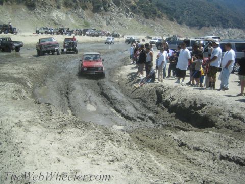 1987 Suzuki Samurai - A 1987 Suzuki Samurai tackles a challenging mud pit during an off-road event.