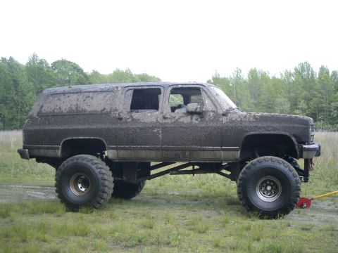 1991 Chevrolet Suburban - This lifted 1991 Chevrolet Suburban is heavily covered in mud, suggesting it has been used for off-roading.