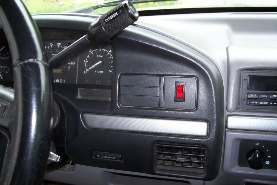 Dashboard with steering wheel, tachometer, overdrive shifter, and radio