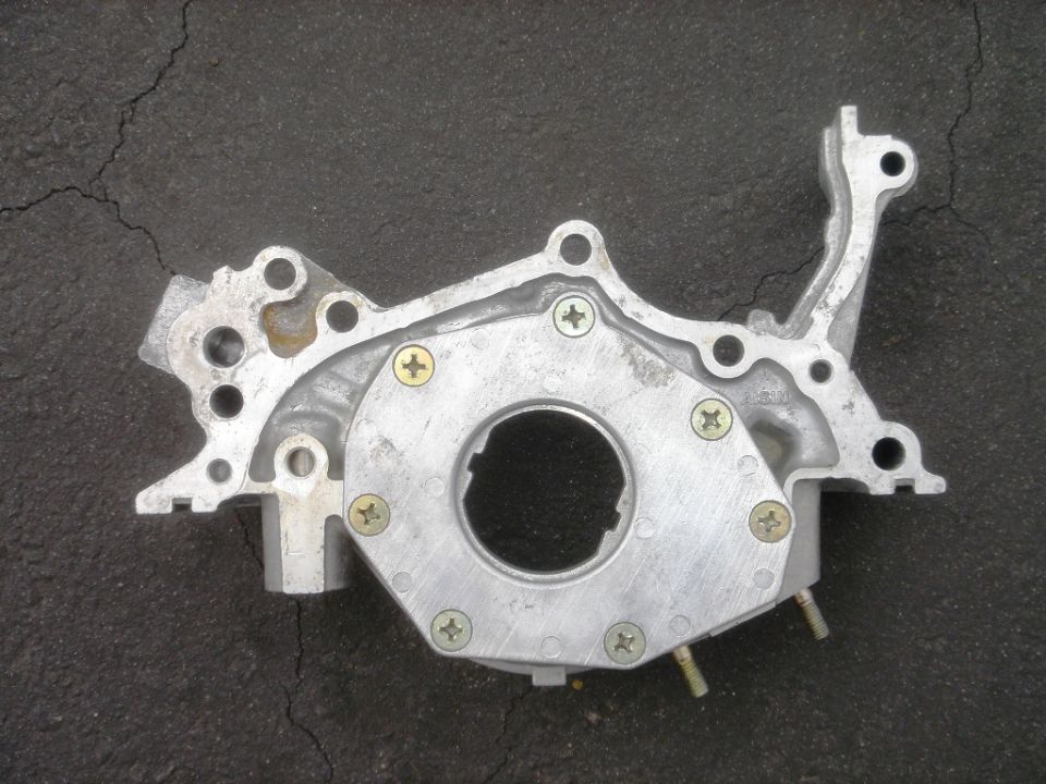 Aluminum oil pump with visible screws and mounting holes