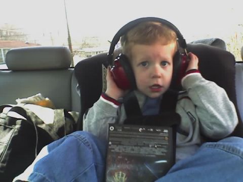 1995 Ford Bronco - A young boy sits in a vehicle, wearing headphones and holding a DVD.
