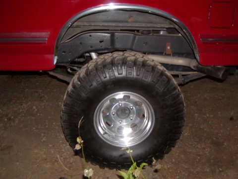 1991 Ford Bronco - Rear wheel and fender detail of a red 1991 Ford Bronco.