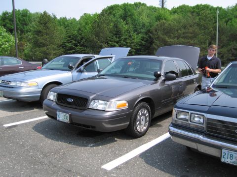 1991 Ford LTD Crown Victoria - A dark gray 1991 Ford Crown Victoria LTD is parked in a lot with other vehicles, showing its front end and license plate.
