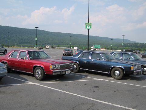 1991 Ford LTD Crown Victoria - Two Ford Crown Victoria LTDs parked in a lot. The red one is in the foreground.