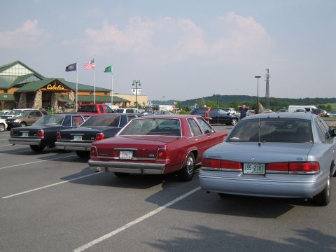 1991 Ford LTD Crown Victoria - Cars parked in a lot outside a Cabela's store on a sunny day.