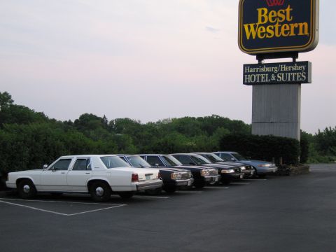 1991 Ford LTD Crown Victoria - Several sedans are parked in a lot near a Best Western hotel sign.