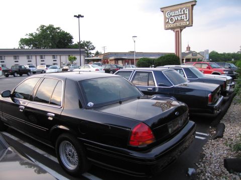 1991 Ford LTD Crown Victoria - A black 1991 Ford Crown Victoria LTD is parked in a lot next to other vehicles.
