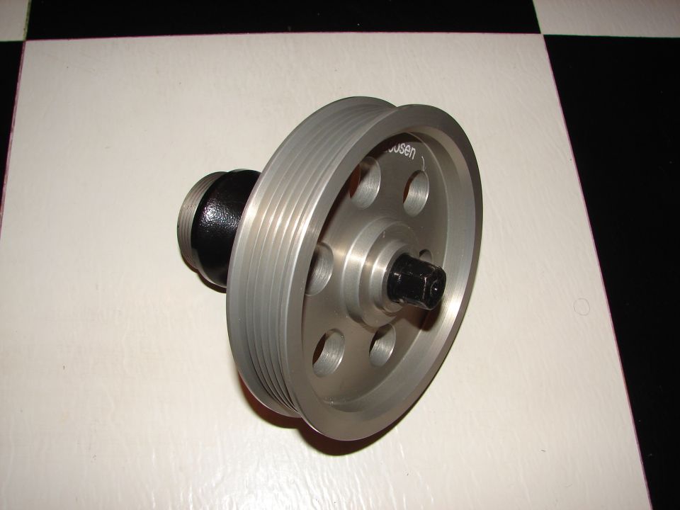 Pulley with 'usen' visible on it, mounted on a black adapter