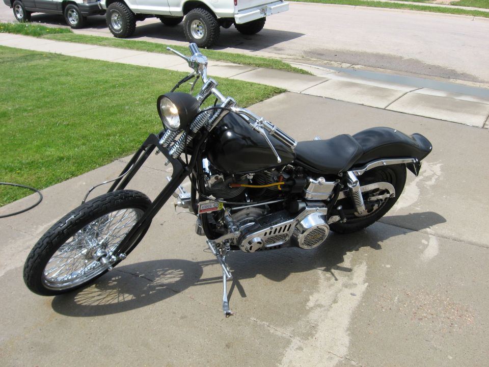 Black Harley-Davidson chopper with extended front end and Shovelhead engine parked on a concrete driveway