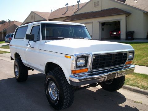1979 Ford Bronco - A white 1978 Ford Bronco is shown from a three-quarter front view, parked on a street in front of houses.