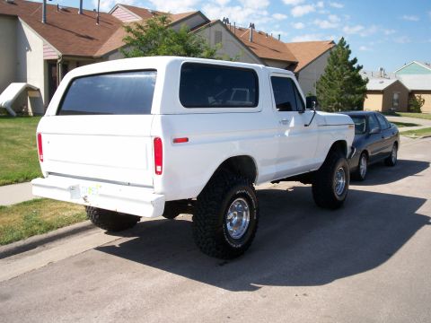 1979 Ford Bronco - White 1979 Ford Bronco with lifted suspension parked on a residential street.