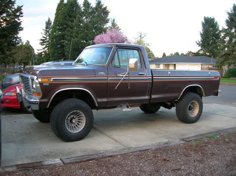 1978 Ford F-250 - A lifted 1978 Ford F-250 pickup truck is parked on a concrete driveway in front of a house.