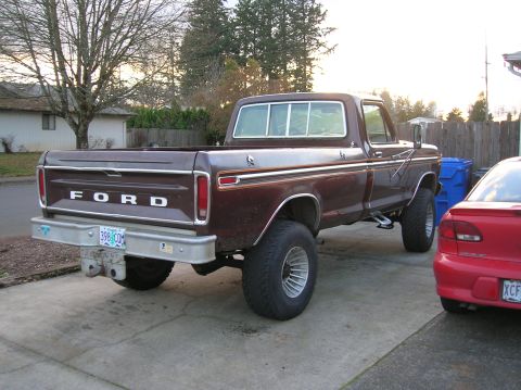 1978 Ford F-250 - This Ford pickup truck has a lifted suspension and large tires. A red car is parked to its right.