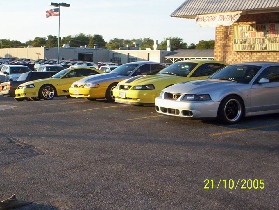 Silver 2003 Ford Mustang parked in a lot, front 3/4 view, black wheels
