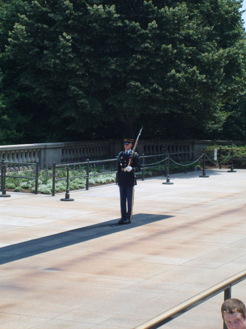 2004 Ford Crown Victoria - A sentry stands guard at a memorial site, holding a rifle at attention.