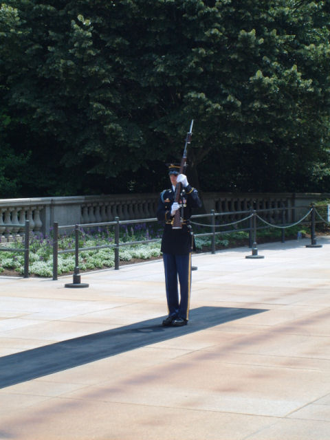 2004 Ford Crown Victoria - A soldier stands guard with a rifle at a memorial site.