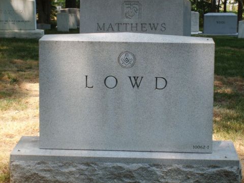2004 Ford Crown Victoria - Gravestones stand in a cemetery under a clear sky, with names and symbols etched into the stone.