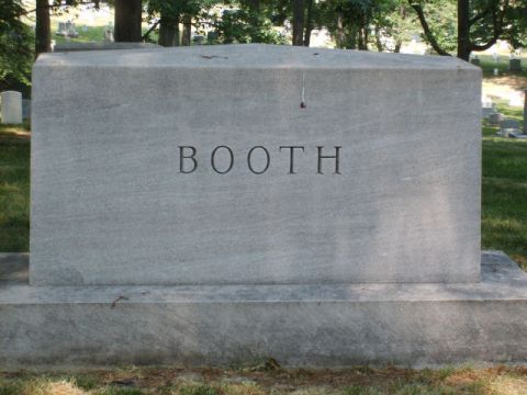 2004 Ford Crown Victoria - Tombstone with the name BOOTH is visible in a cemetery with trees and other headstones in the background.