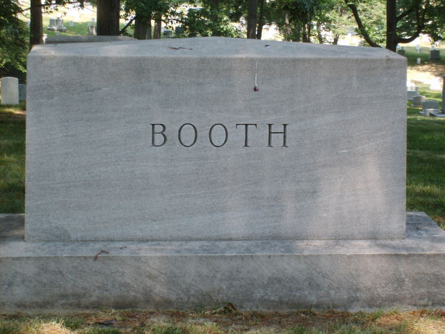Large granite tombstone with the name BOOTH carved into it, set in a grassy cemetery