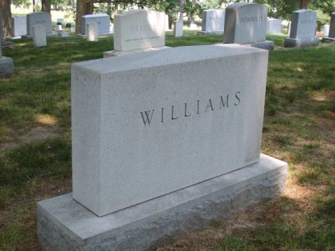 2004 Ford Crown Victoria - A large granite tombstone bearing the name 'WILLIAMS' stands in a cemetery on a sunny day.