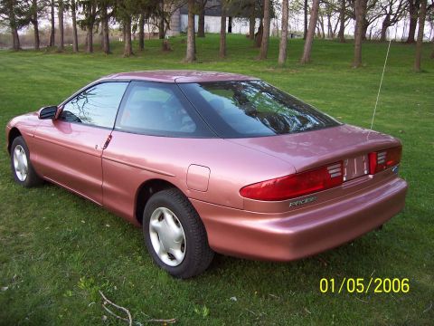 1996 Ford Probe - A 1996 Ford Probe is parked on a grassy lawn with trees in the background.