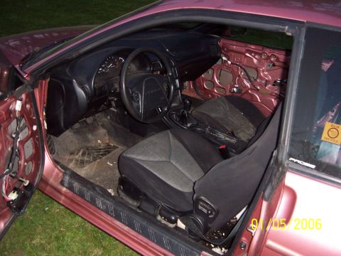 1996 Ford Probe - The interior of a car is shown with the doors removed, revealing the dashboard and seats.