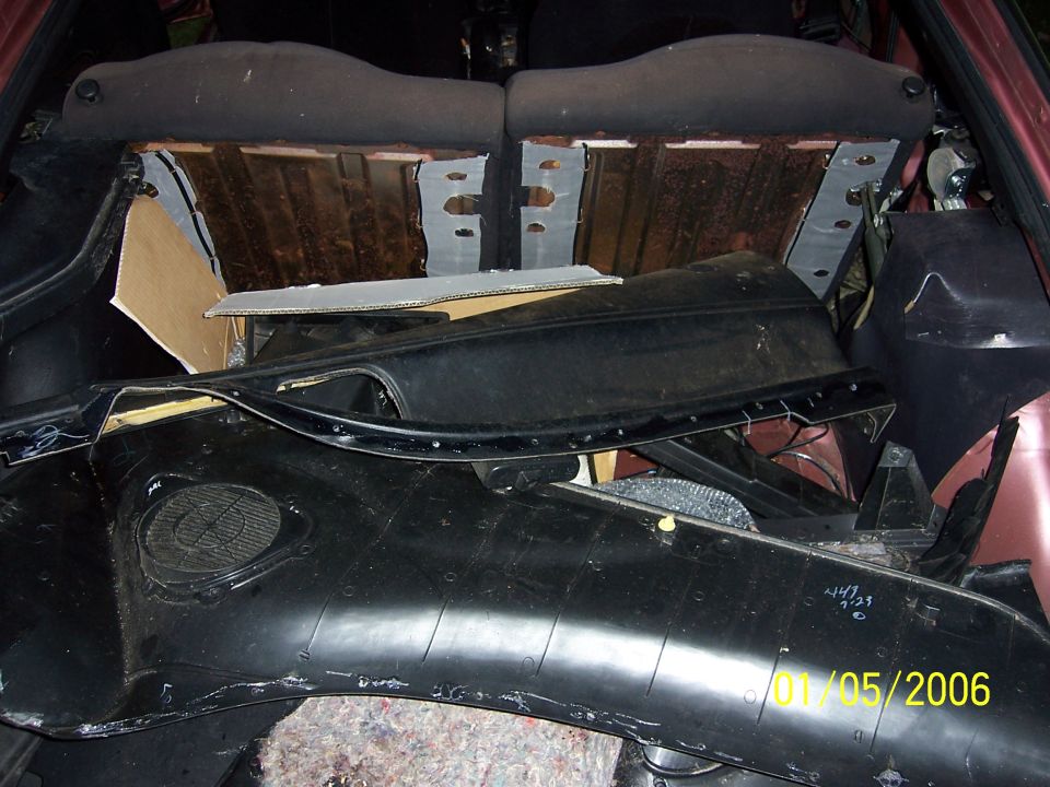 Car interior parts piled in a vehicle's cargo area. Date stamp reads 01/05/2006