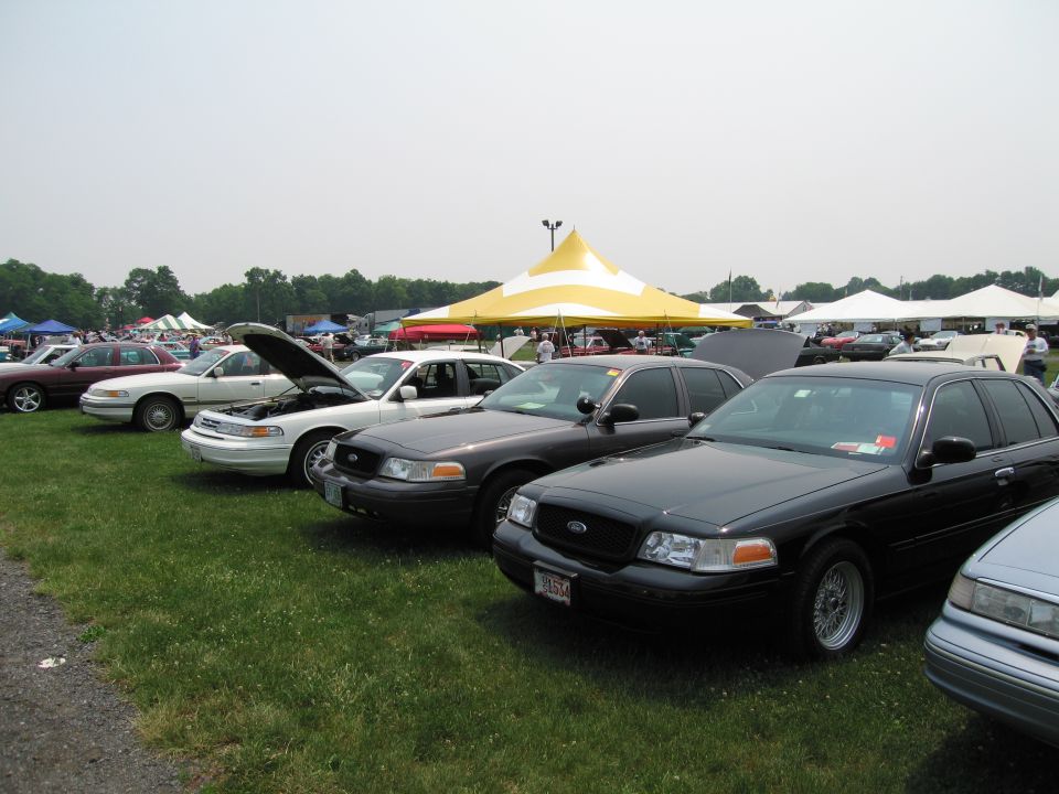 Black 1991 Ford Crown Victoria LTD with a license plate reading 'V6574' parked on grass