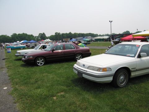 1991 Ford LTD Crown Victoria - White 1992 Ford Crown Victoria parked on grass with other vehicles and tents in the background.