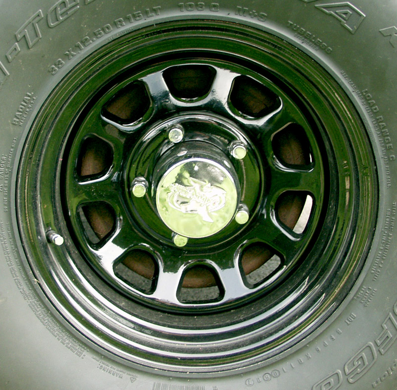 Black steel wheel with chrome center cap on a 33x12.50R15LT off-road tire