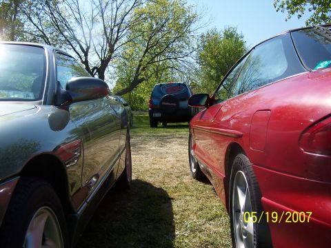 1996 Ford Probe - Three vehicles are parked on a grassy area under trees, with a date stamp of 05/19/2007 visible on the red car.