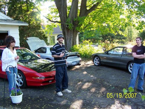 1996 Ford Probe - A gathering of people with three cars, including two Ford Probes, on a sunny day.