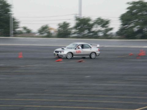2001 Mercury Grand Marquis - Silver sedan with racing number 126 navigates an asphalt track marked with orange cones.