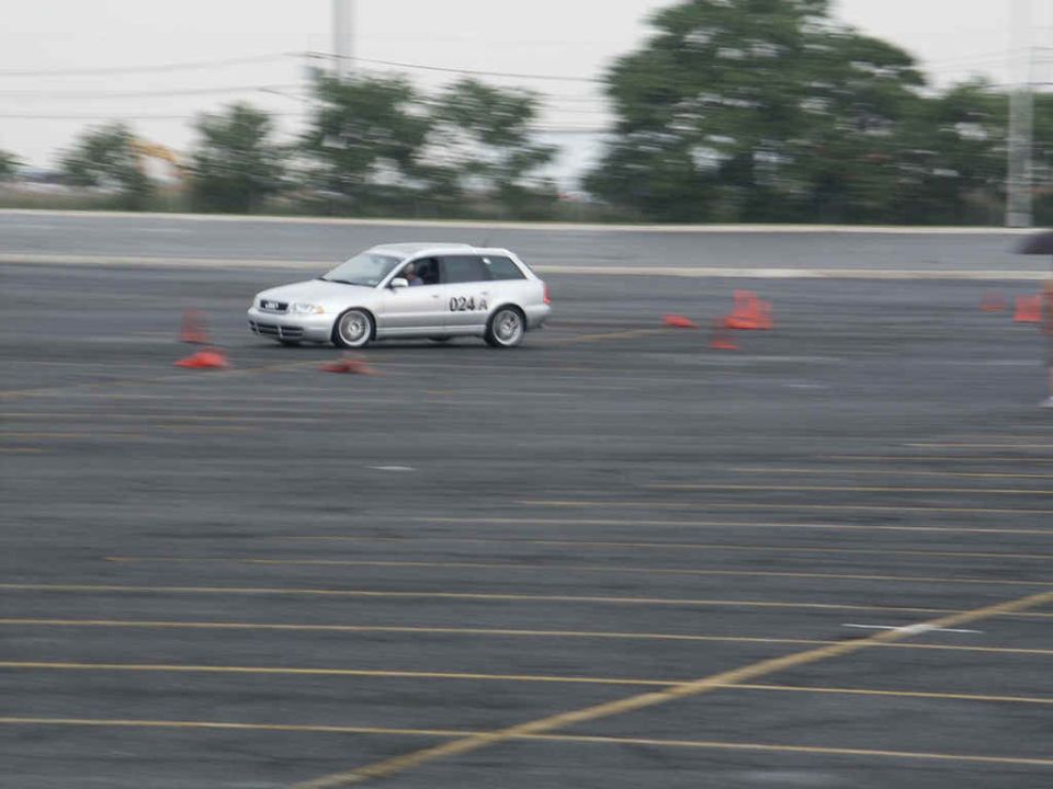 Silver station wagon driving on a track with orange cones
