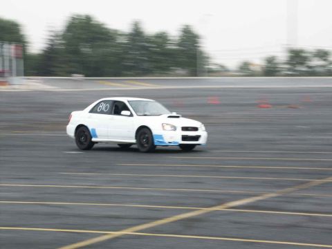 2001 Mercury Grand Marquis - A white Subaru Impreza WRX with racing markings is seen on a track during an event.