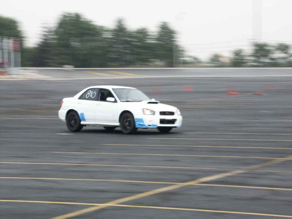 White Subaru Impreza WRX with number 810 on door, on a race track