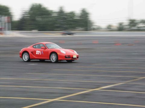 2001 Mercury Grand Marquis - A red Porsche Cayman is seen on a track, likely during a performance driving event or race.