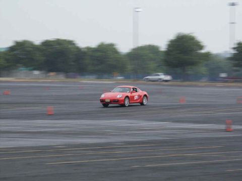 2001 Mercury Grand Marquis - A red sports car navigates a course marked by orange cones on a cloudy day.