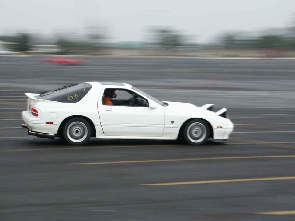 White Mazda RX-7 side view, motion blurred