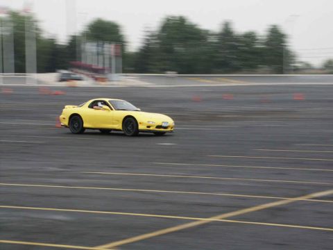 2001 Mercury Grand Marquis - Yellow Mazda RX-7 FD seen drifting on a paved track during an event.