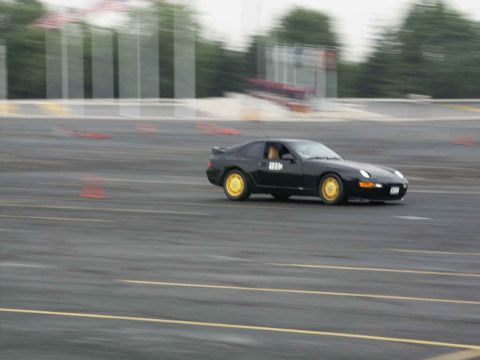 2001 Mercury Grand Marquis - A black coupe with yellow wheels navigates a track, captured with motion blur.