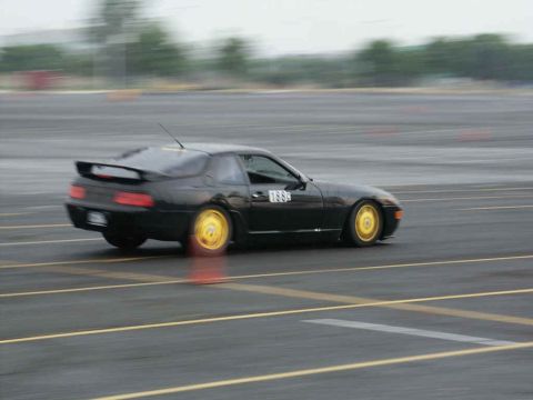 2001 Mercury Grand Marquis - A black coupe with bright yellow wheels is seen on a track, with the number 1889 displayed on its side.