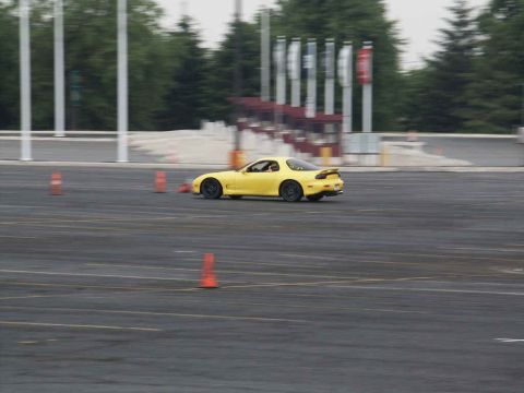 2001 Mercury Grand Marquis - A yellow sports car navigates a cone-marked track during a timed event.