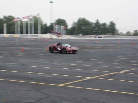 2001 Mercury Grand Marquis - Sports car navigates a course marked by orange cones on an asphalt track.