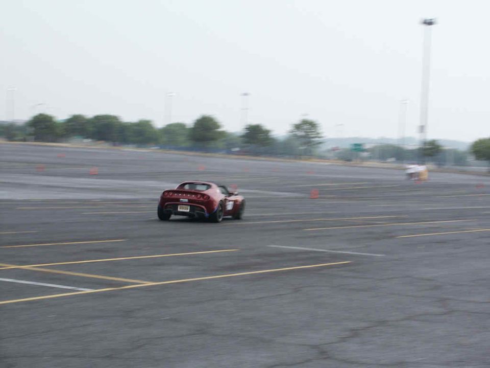 Red sports car on a track with orange cones