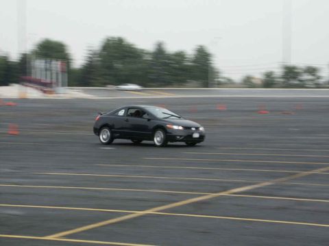 2001 Mercury Grand Marquis - A black sedan navigates a course marked by orange cones on a paved surface.