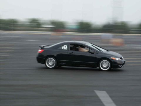 2001 Mercury Grand Marquis - Black coupe with racing number 37 on door, captured in motion on a wet asphalt track.