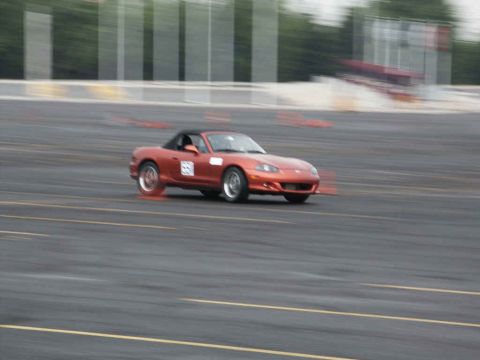 2001 Mercury Grand Marquis - A sports car navigates a course marked by traffic cones, with motion blur indicating speed.